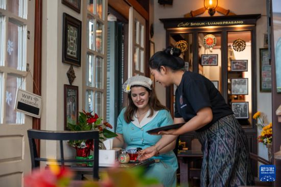 在老挝琅勃拉邦一家咖啡店，服务员为顾客端上咖啡（2025年12月31日摄）。新华社发（凯乔摄）