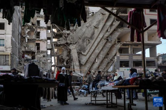 这是1月15日在加沙城一处集市拍摄的往来人群。新华社发（里泽克·阿卜杜勒贾瓦德摄）