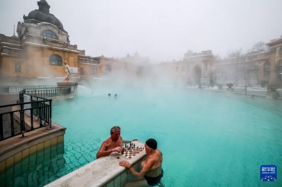 1月16日，人们在雪后的匈牙利布达佩斯塞切尼温泉中下象棋。新华社发（鲍洛格·达维德摄）