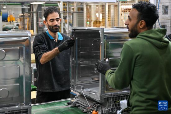 1月19日,在埃及苏赫奈泉的中埃·泰达苏伊士经贸合作区,埃及员工在美的埃及厨房和热水器有限公司洗碗机生产车间组装洗碗机。新华社记者 辛梦晨 摄
