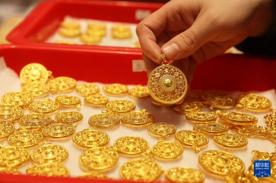 1月28日,员工在位于浙江省杭州市萧山区瓜沥镇的杭州航民百泰首饰有限公司展厅整理黄金首饰。新华社发(倪立芳摄)