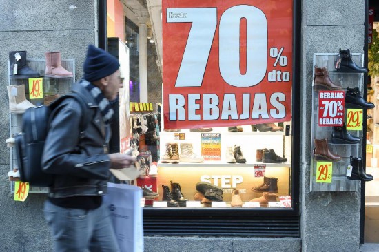 1月7日,市民经过西班牙马德里市中心的打折招牌。新华社发(古斯塔沃·巴连特摄)