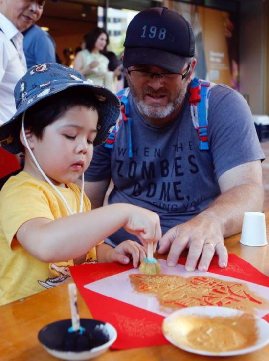 2月1日,在澳大利亚珀斯的西澳大利亚博物馆,当地儿童在家长陪同下拓印新年福贴。(周丹 摄)
