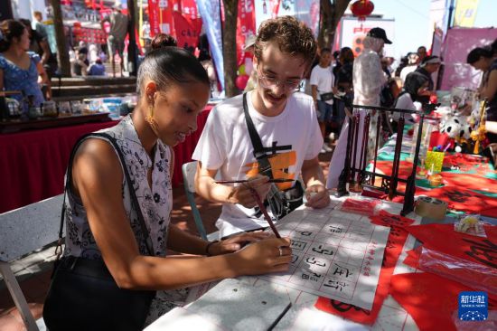 2月1日，人们在南非开普敦维多利亚港区举行的中国年庆祝活动上体验中国书法。新华社记者 王雷 摄
