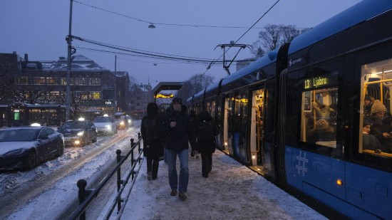 2025年1月6日,在挪威首都奥斯陆,乘客在雪中上下车。新华社记者张玉亮摄