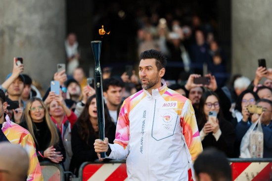 2025年12月6日，在意大利罗马万神殿，火炬手、意大利篮球运动员安德烈亚·巴尔尼亚尼在传递火炬。当日，2026年米兰-科尔蒂纳冬奥会火炬在意大利罗马传递。新华社记者李京摄