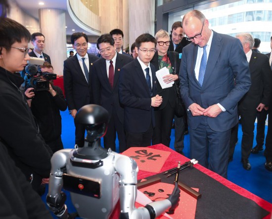 2月26日,德国总理默茨在杭州宇树科技观看机器人写“福”字。新华社记者 翁忻旸 摄