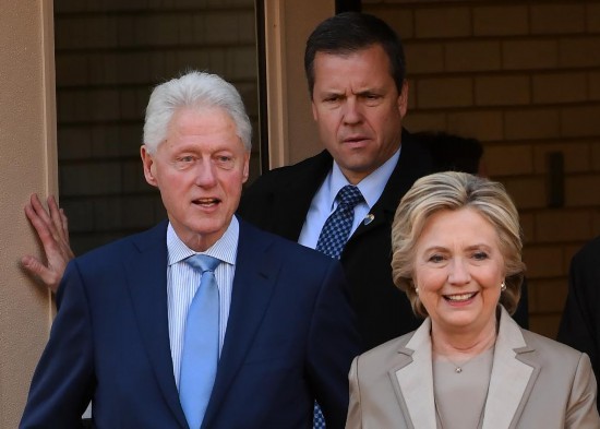 2016年11月8日,在美国纽约州查帕阔一处投票站,希拉里·克林顿(前右)与她的丈夫、前总统比尔·克林顿参加大选投票。新华社记者殷博古摄