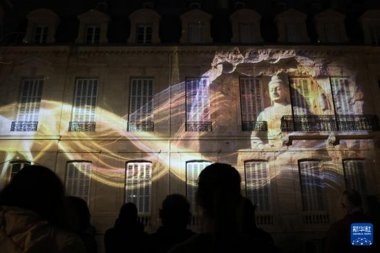 2月26日，当地民众聚集在法国巴黎中国文化中心的庭院内观赏“云冈石窟之光·巴黎回响”光雕秀。新华社记者 张百慧 摄