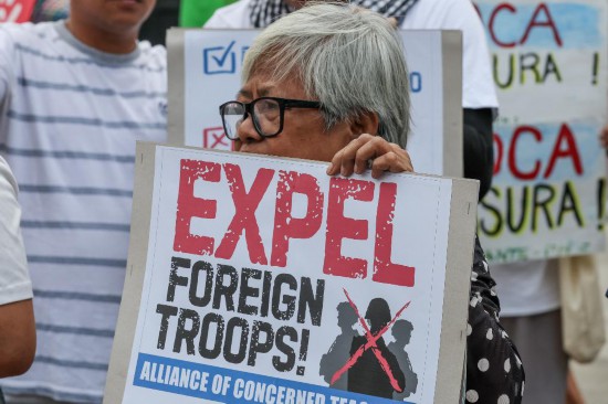 　　4月20日，民众手持标语在菲律宾武装部队总部外集会抗议美菲“肩并肩”联合军演。新华社发（乌马利摄）