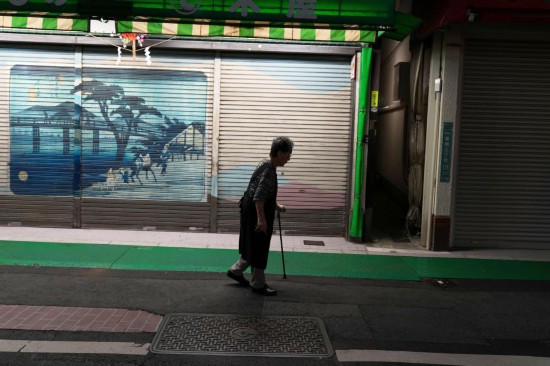 2023年9月，在日本东京巢鸭，一位老年人路过商业街。新华社记者张笑宇摄