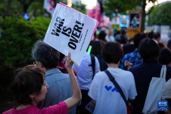5月19日，在位于日本东京的国会议事堂前，民众手持标语参加抗议集会。新华社记者 贾浩成 摄