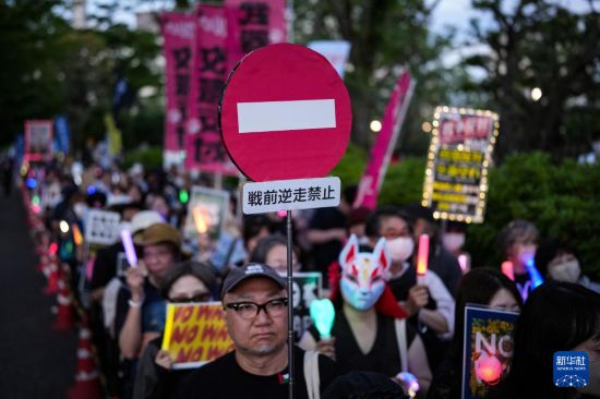 5月19日，在位于日本东京的国会议事堂前，民众手持标语参加抗议集会。新华社记者 贾浩成 摄