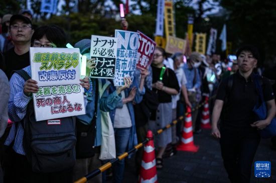 5月19日，在位于日本东京的国会议事堂前，民众手持标语参加抗议集会。新华社记者 贾浩成 摄