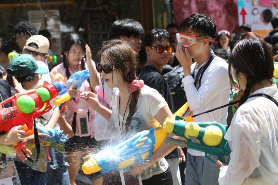 4月13日，人们在泰国曼谷街头参加泼水节庆祝活动。新华社发（拉亨摄）