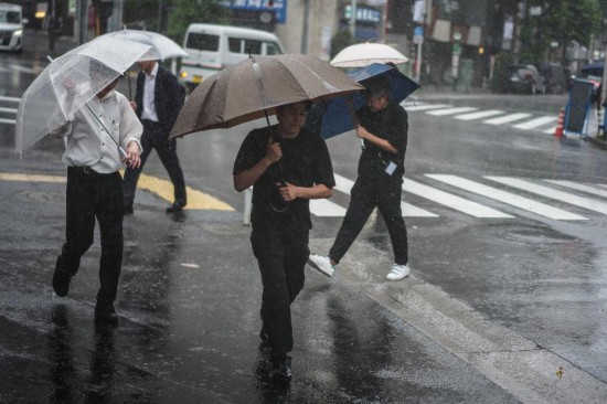 6月3日,在日本东京,行人撑伞在街头行走。新华社记者贾浩成摄