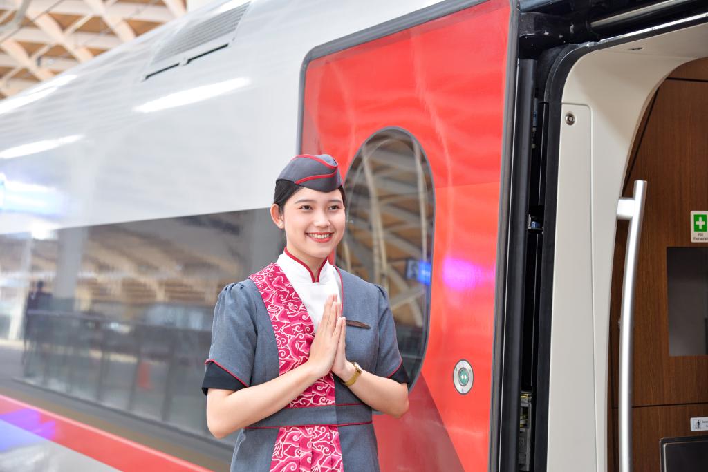 12月12日,乘务人员在印度尼西亚雅加达的哈利姆车站站台欢迎乘坐雅万高铁的乘客。新华社记者徐钦摄