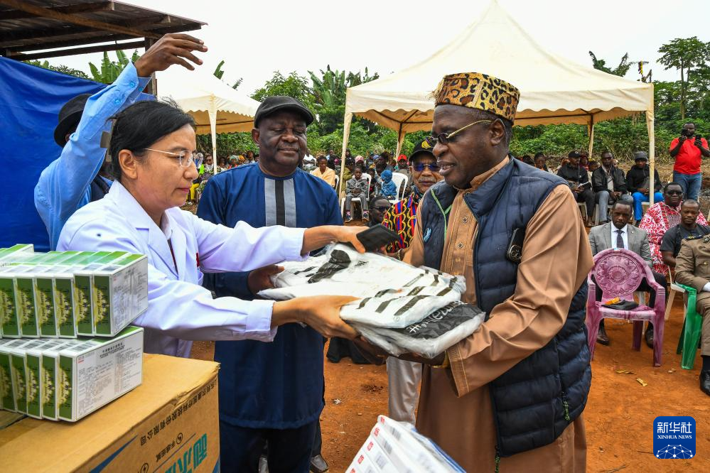 7月24日,在喀麦隆首都雅温得郊外的阿法诺亚村,中国援喀麦隆医疗队队员向当地人发放医疗物资。新华社发(科普索摄)