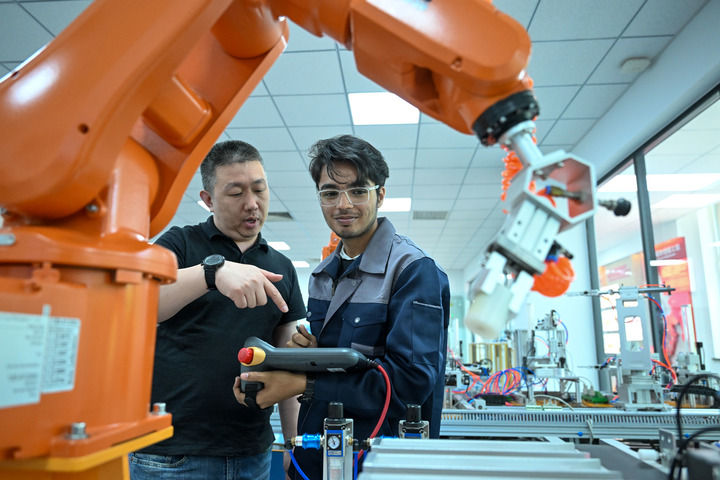 在天津现代职业技术学院鲁班工坊实训教室,教师指导学生操作设备(2025年6月16日摄)。新华社记者 孙凡越 摄