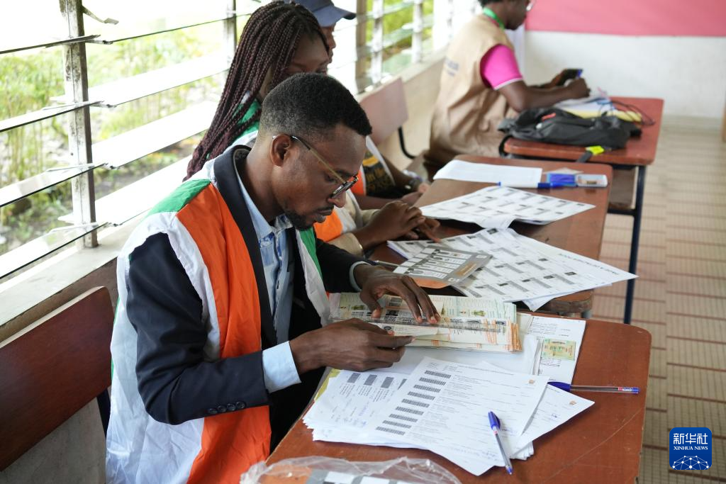 10月25日,工作人员在科特迪瓦经济首都阿比让的一处投票站核实选民信息。新华社记者 张健 摄