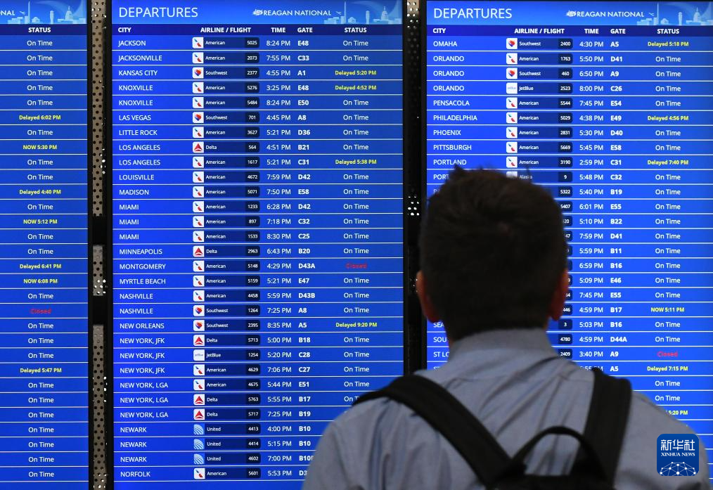 10月10日,在美国弗吉尼亚州阿灵顿的里根国家机场,一名男子查看航班信息。新华社记者 李睿 摄