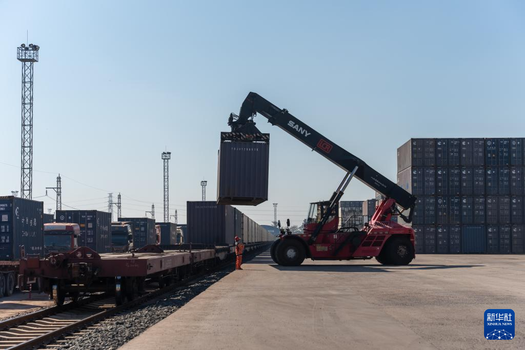 11月29日,在老挝首都万象中老铁路万象南站,工作人员进行集装箱吊装作业。新华社发(凯乔摄)