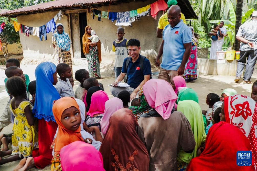 1月1日，在坦桑尼亚桑给巴尔的奔巴岛，中国援助坦桑尼亚“桑给巴尔血吸虫病防治技术项目”专家组队长汪伟（中）与当地儿童交流，开展健康宣教。新华社发（赫尔曼·埃马纽埃尔摄）