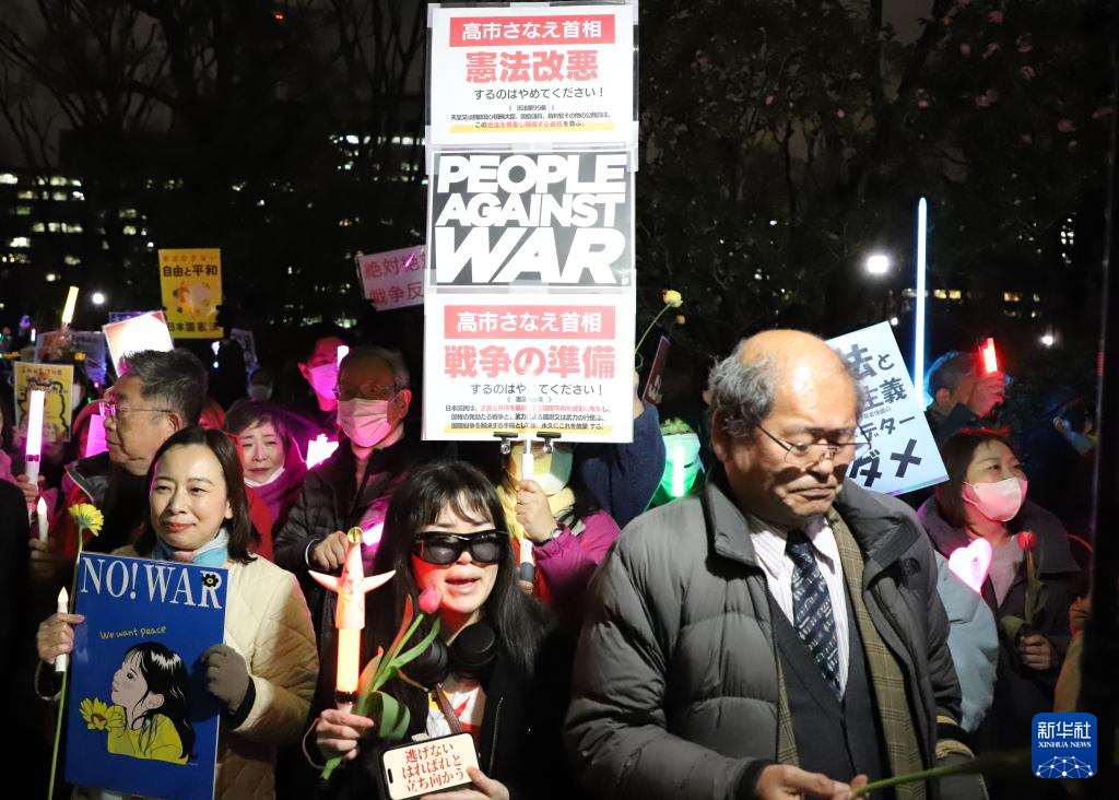 3月10日，在位于东京的日本国会门前，民众手持标语参加抗议活动。新华社记者 李子越 摄