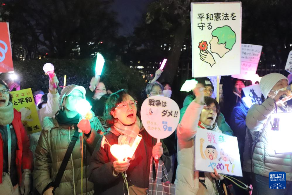 3月10日，在位于东京的日本国会门前，民众手持标语参加抗议活动。新华社记者 李子越 摄
