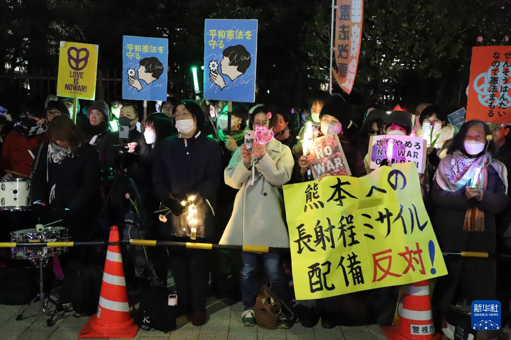 3月10日，在位于东京的日本国会门前，民众手持标语参加抗议活动。新华社记者 李子越 摄